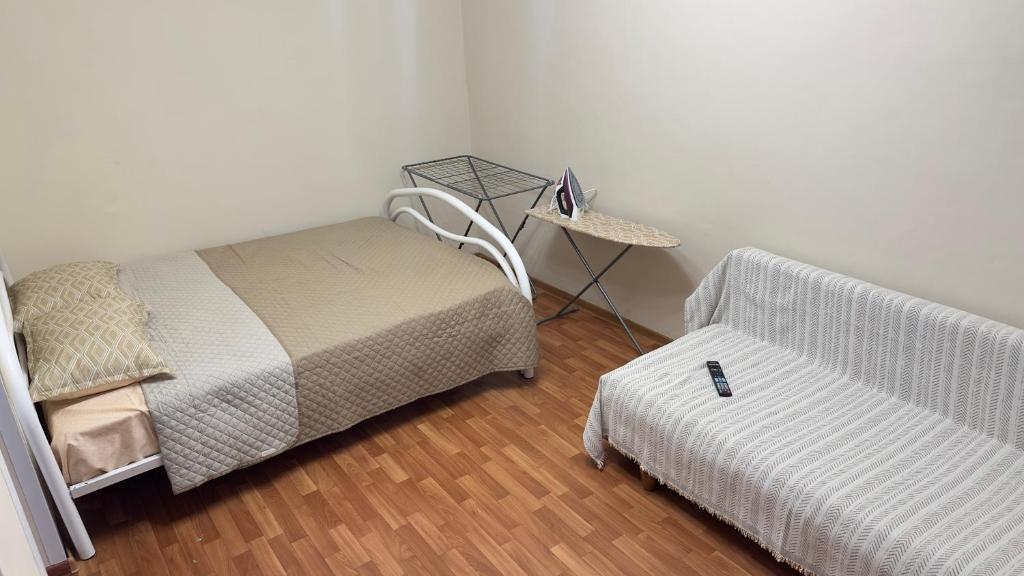 a bedroom with a bed and a chair and a table at Апартаменты 3а in Aktau