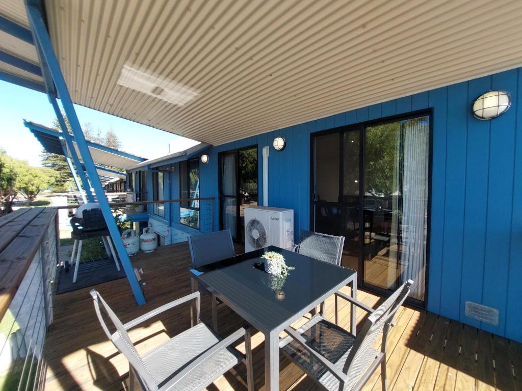 a blue house with a table and chairs on a deck at Blue Oasis in Esperance