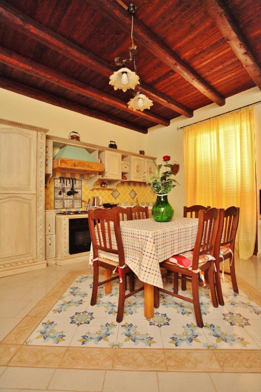 a dining room with a table and chairs and a kitchen at Villa Salvatore in San Leone