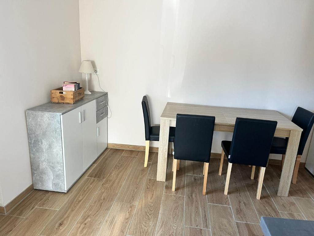 a dining room with a table and chairs and a refrigerator at Ferienwohnung am Nürburgring in Herresbach