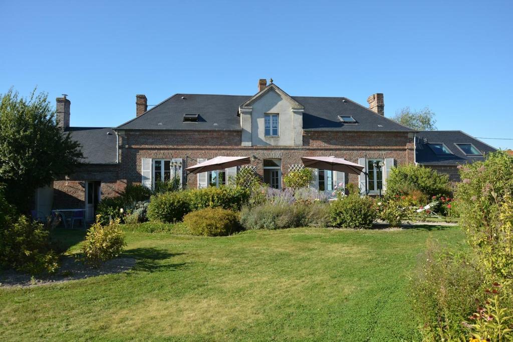 a large brick house with a large yard at Bienvenu dans le Java chez Pommes & Chevaux in Favières