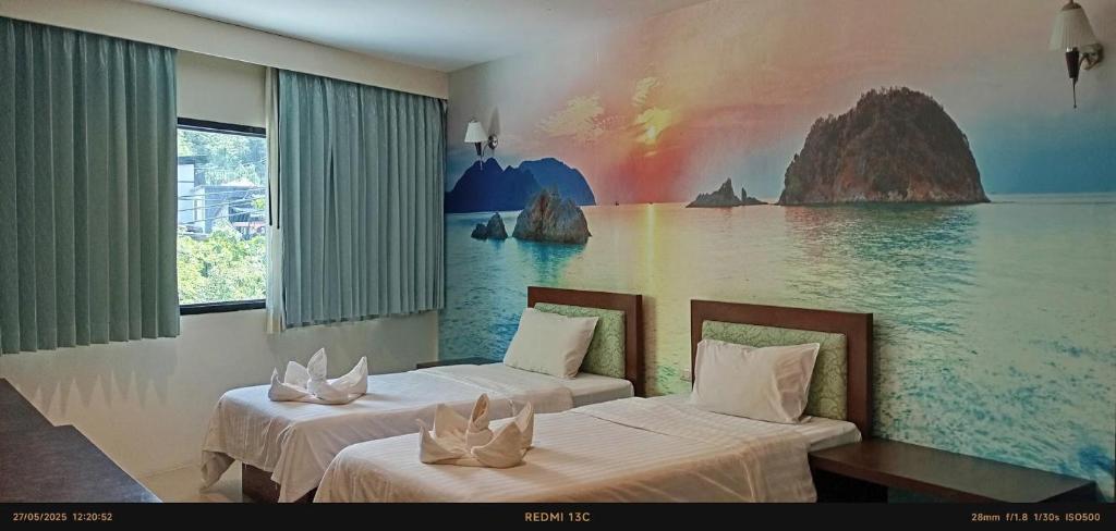 two beds in a room with a painting on the wall at Sea Star House in Ao Nang Beach