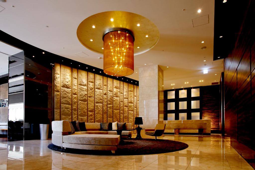 a lobby with a couch and a chandelier at Hotel Trusty Osaka Abeno in Osaka