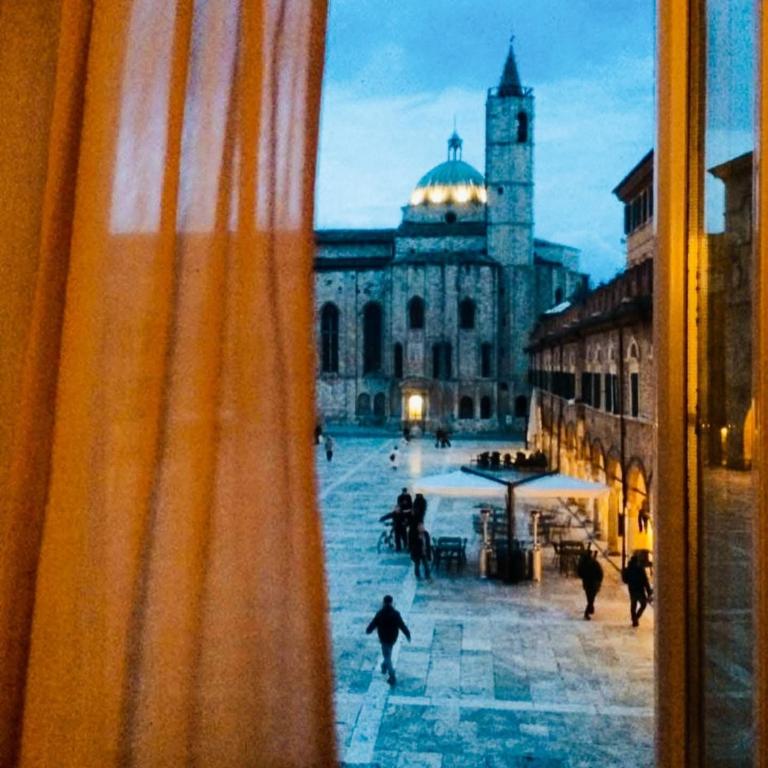 a view of a building with a clock tower from a window at Residenza dei Capitani - Piazza del Popolo in Ascoli Piceno