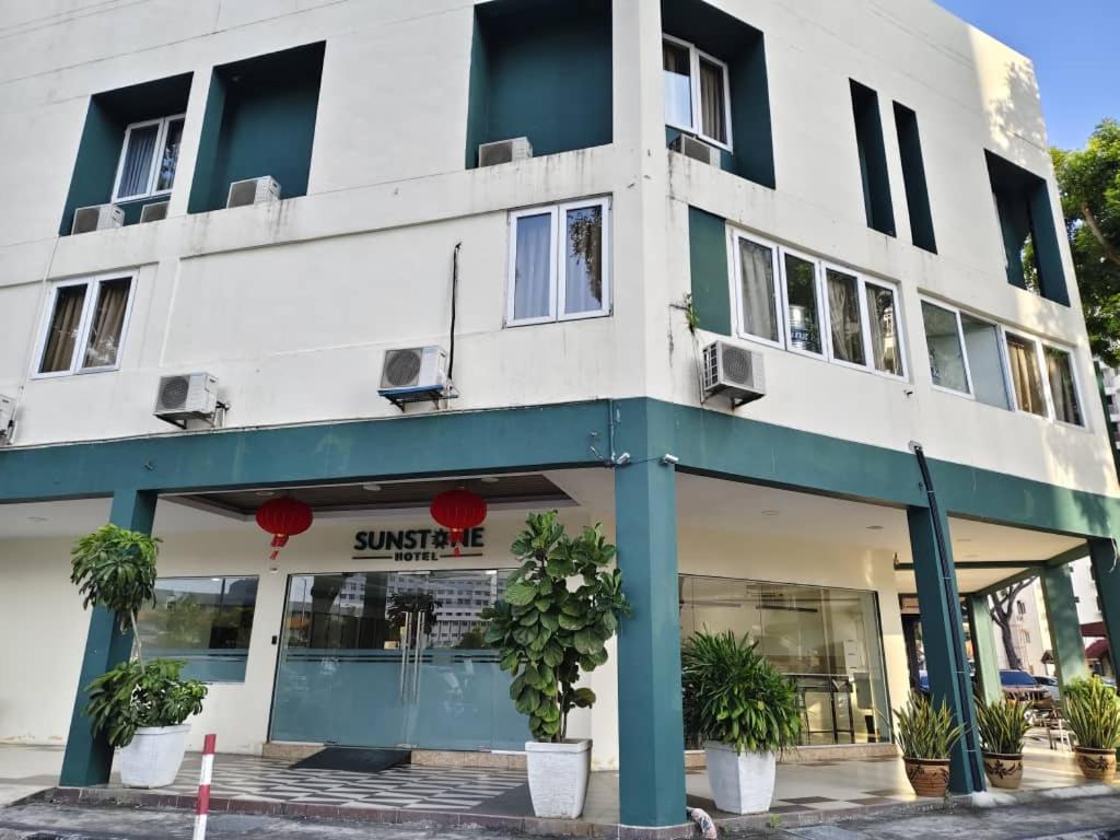 a white and blue building with plants in front of it at Sunstone Hotel in George Town