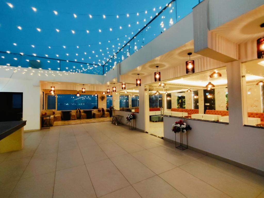 a lobby with a waiting area with lights and couches at HOTEL JVS PALACE in Gorakhpur