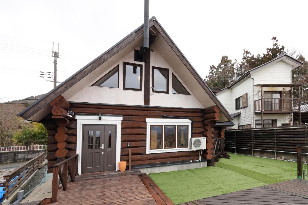 a log cabin with a door on a deck at ヴィラ湖西 最大11名 琵琶湖ビュー165平米の一棟貸切ログハウス BBQハウス完備 広々3LDK ロフト Wi-Fi in Takashima