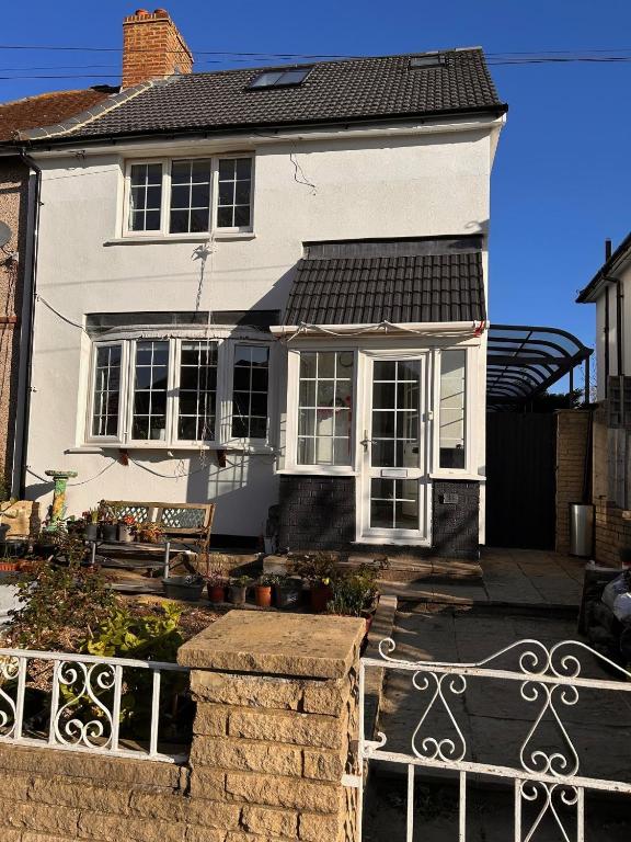 a white house with a fence in front of it at Baoyan Kingston - Guest House with 2 bedrooms with 1 toilet-washing room in Kingston upon Thames