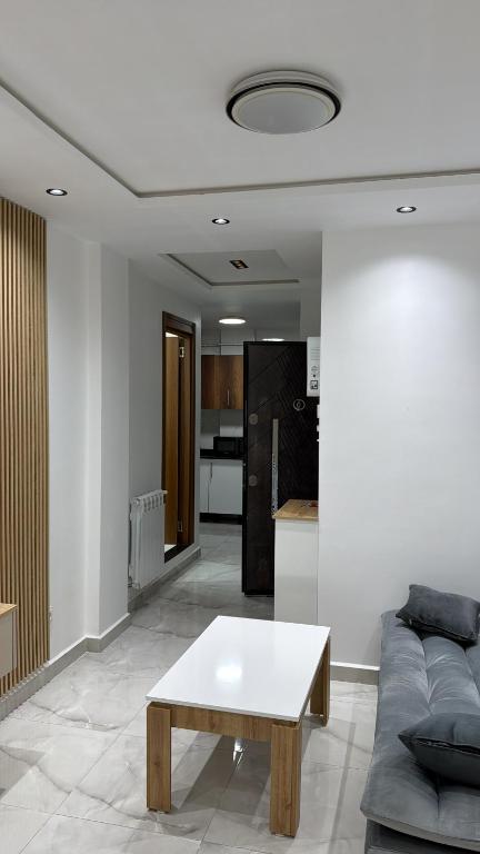 a living room with a couch and a table at Grand studio tout équipé in Ben Mered