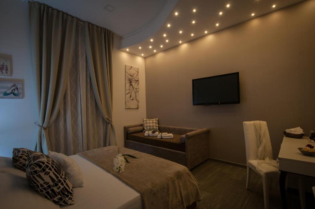 ローマにあるエレーノアル ルーム＆スイートのベッドとテレビが備わるホテルルームです。