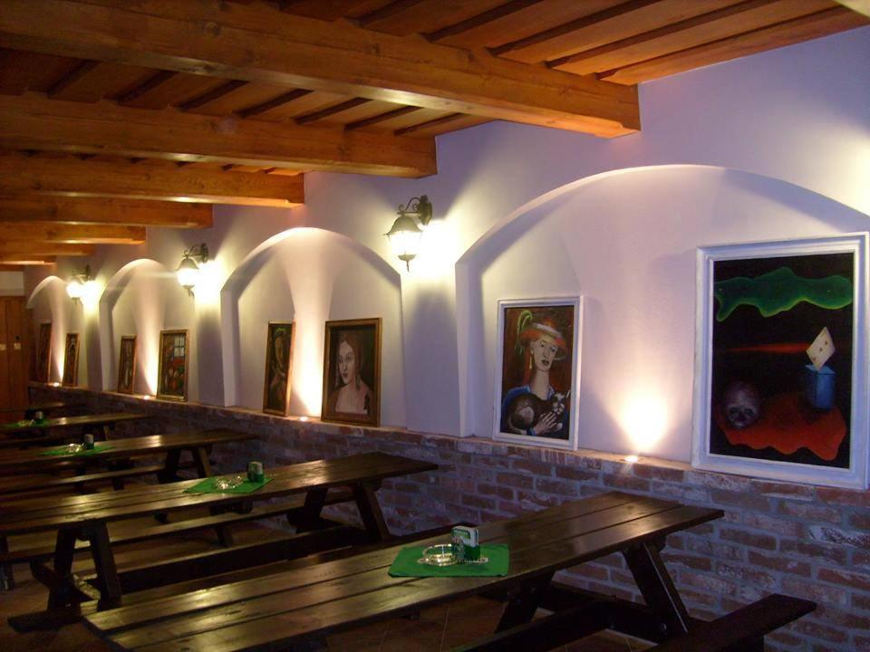 a restaurant with wooden tables in a room with arches at Chatová osada Budín u Žirovnice in Žirovnice
