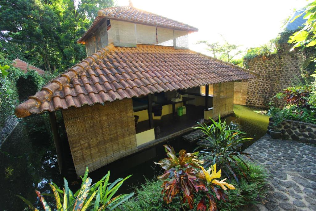 a small house with a tiled roof in a garden at Ecolodge Seloliman in Jatijejer