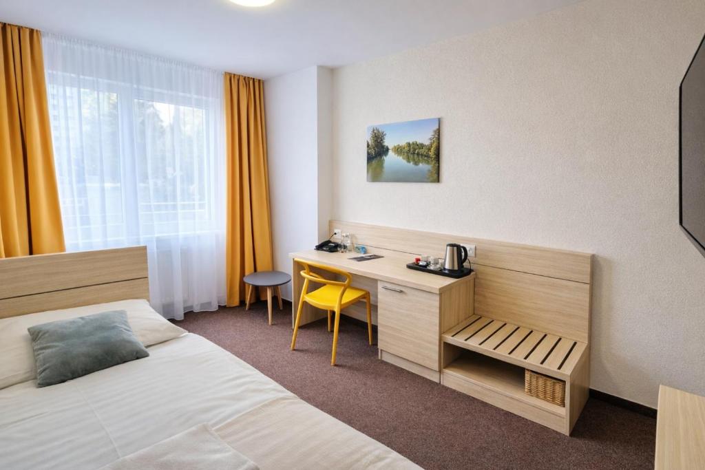 a hotel room with a bed and a desk at Hotel Kristína in Dubnica nad Váhom