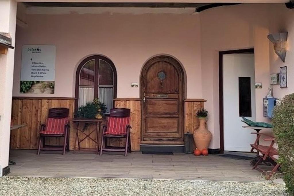a patio with two chairs and a wooden door at Il Giardino in Ilmmünster