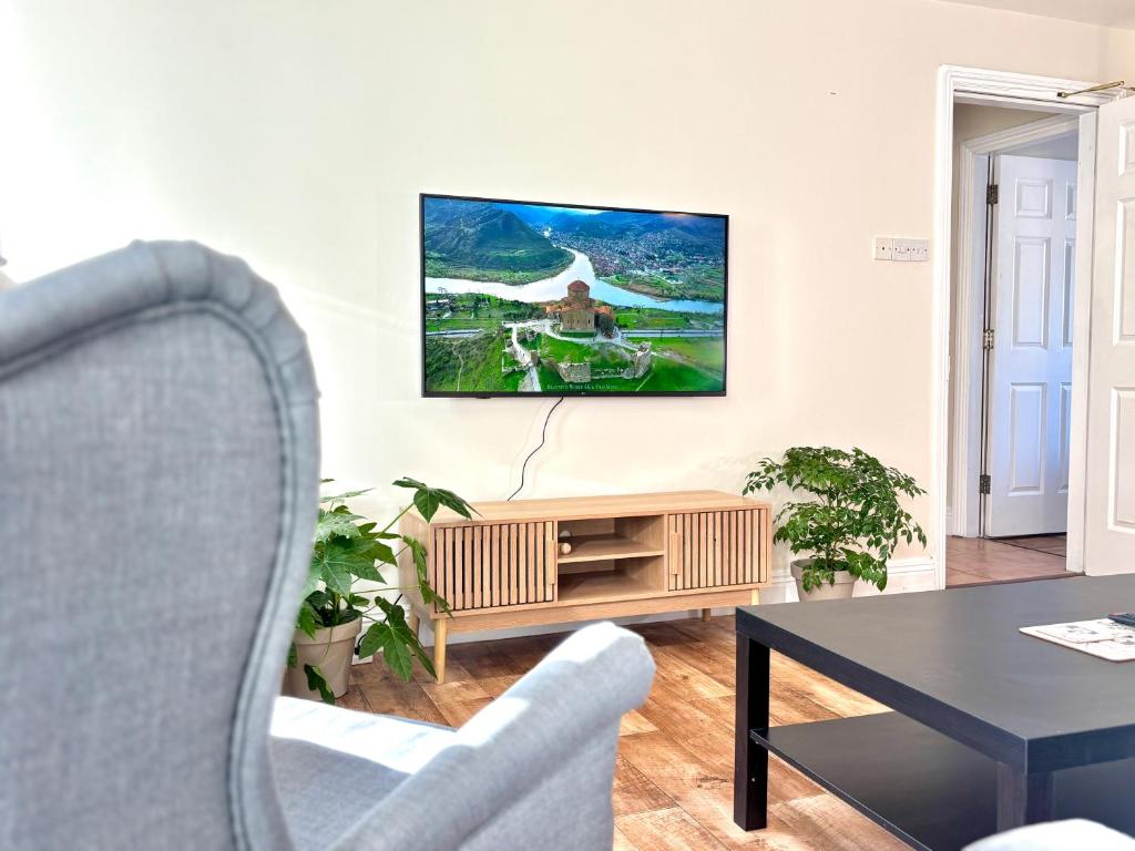 a living room with a table and a tv on the wall at The Seafarers Rest in Cobh