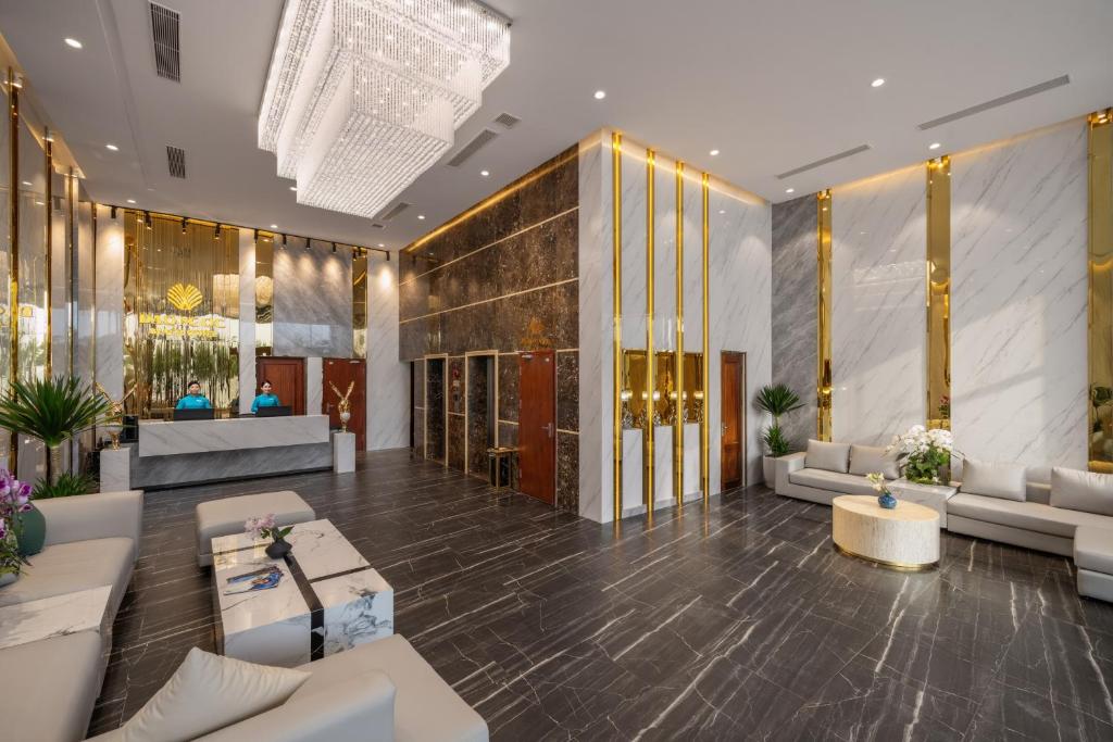 A broad reception-lobby view combines sofas, elevators and a dramatic chandelier.