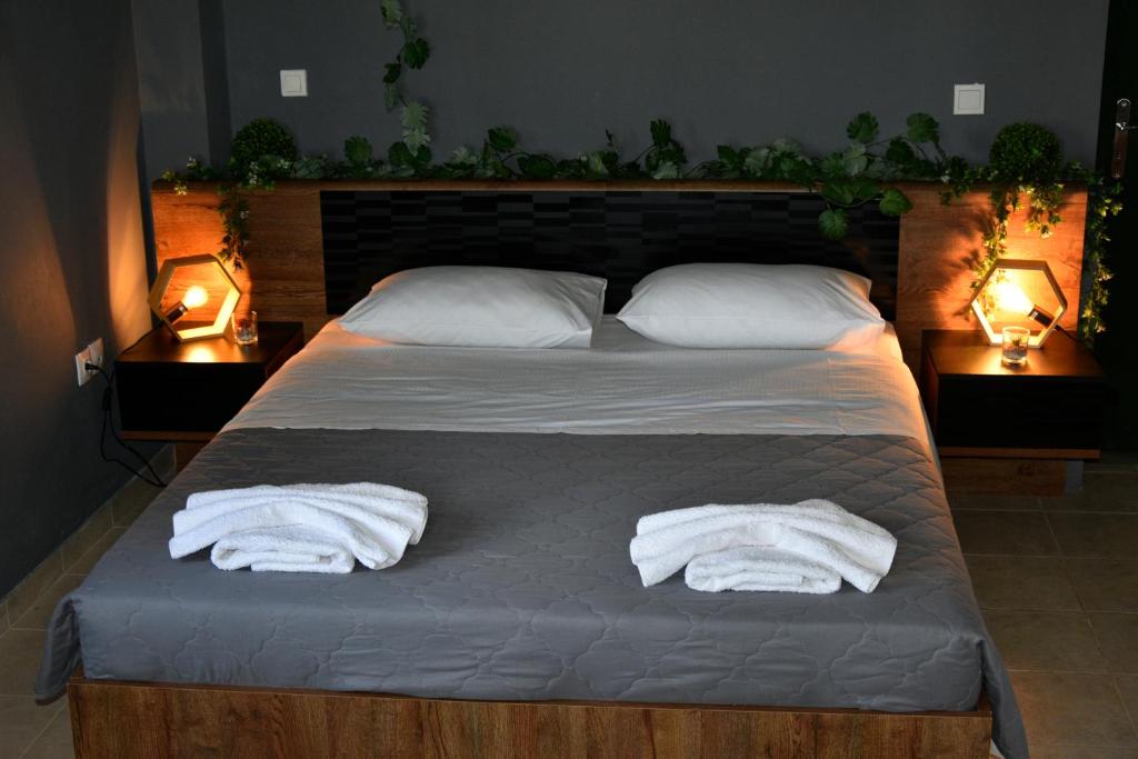 two towels on a bed in a bedroom with two lights at Αλώνι - Aloni in Angathiás