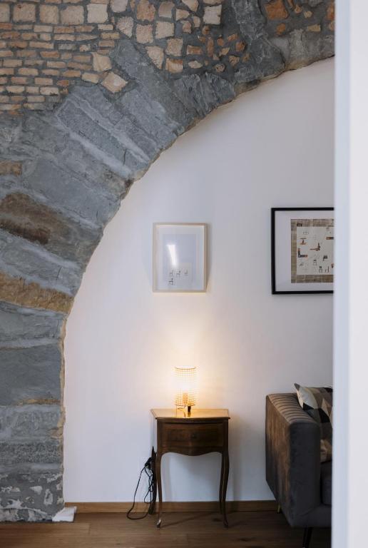 a room with a table and a stone wall at Larco Trieste studio living 3 in Trieste