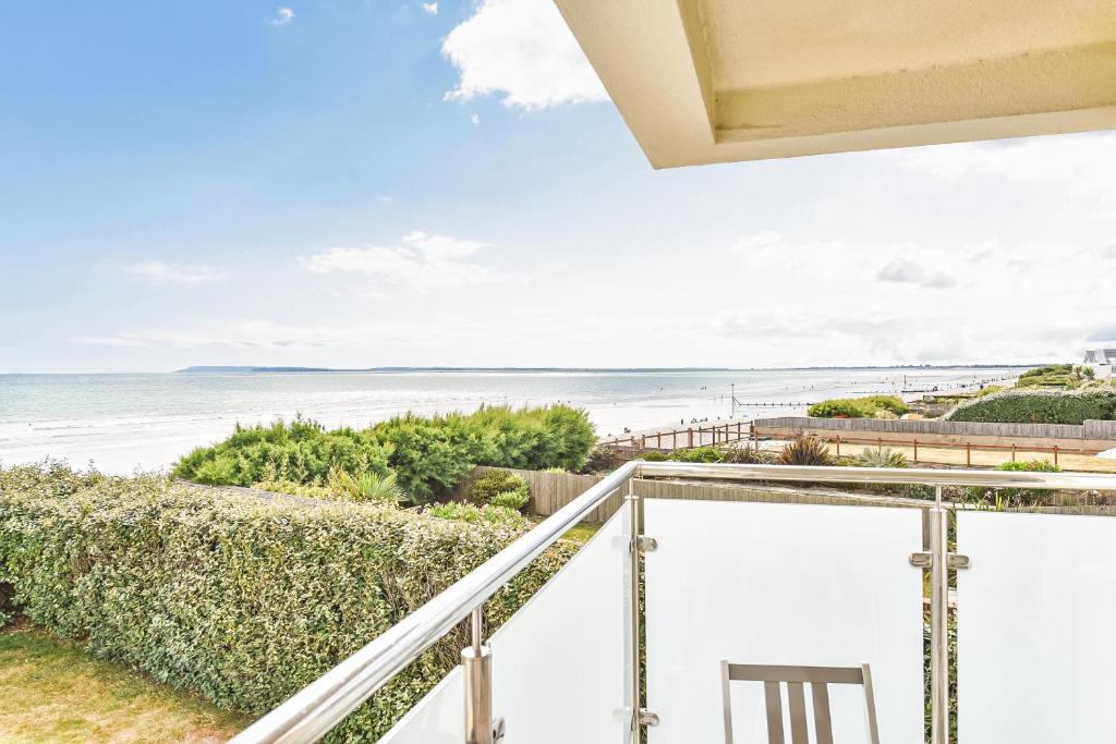 a view of the beach from the balcony of a house at Beach View - East Wittering in Chichester