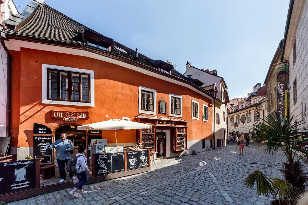 een groep mensen die in een straat naast een gebouw lopen bij Pension Galko in Český Krumlov