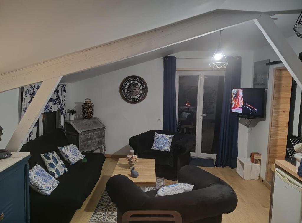 a living room with two couches and a tv at Mise au vert in Saint-Juvin