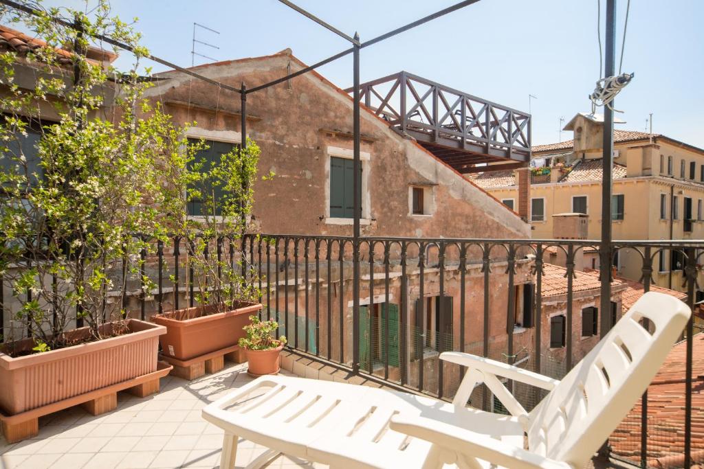 2 sillas blancas en la parte superior de un balcón en Venice Altanina Apartment, en Venecia