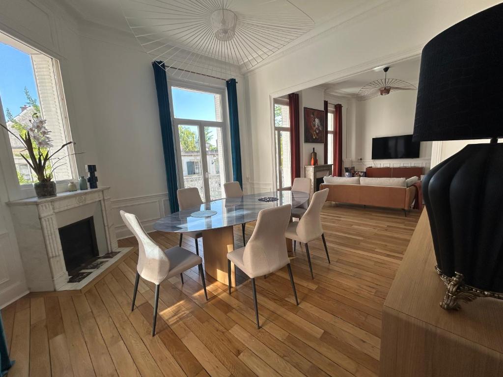 a living room with a dining room table and chairs at LE PALAIS DE LEO Luxury Apt Epernay Hyper center 4P Balcony AC in Épernay