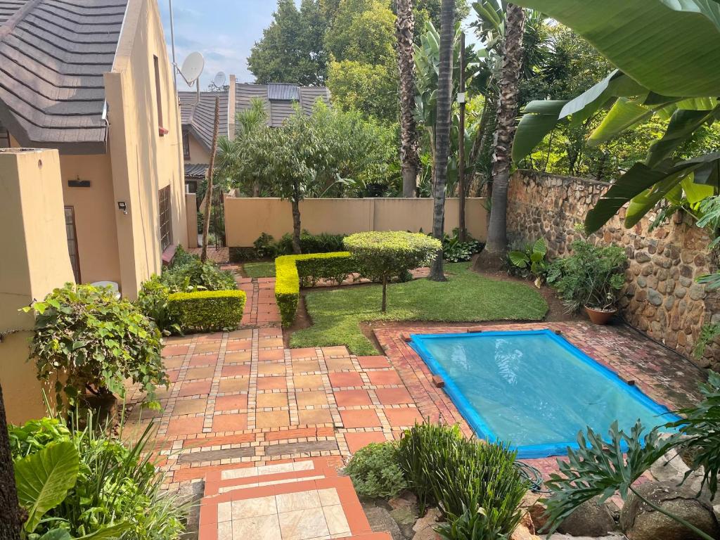 a backyard with a swimming pool and a garden at Lalakamnandi Guesthouse in Pretoria