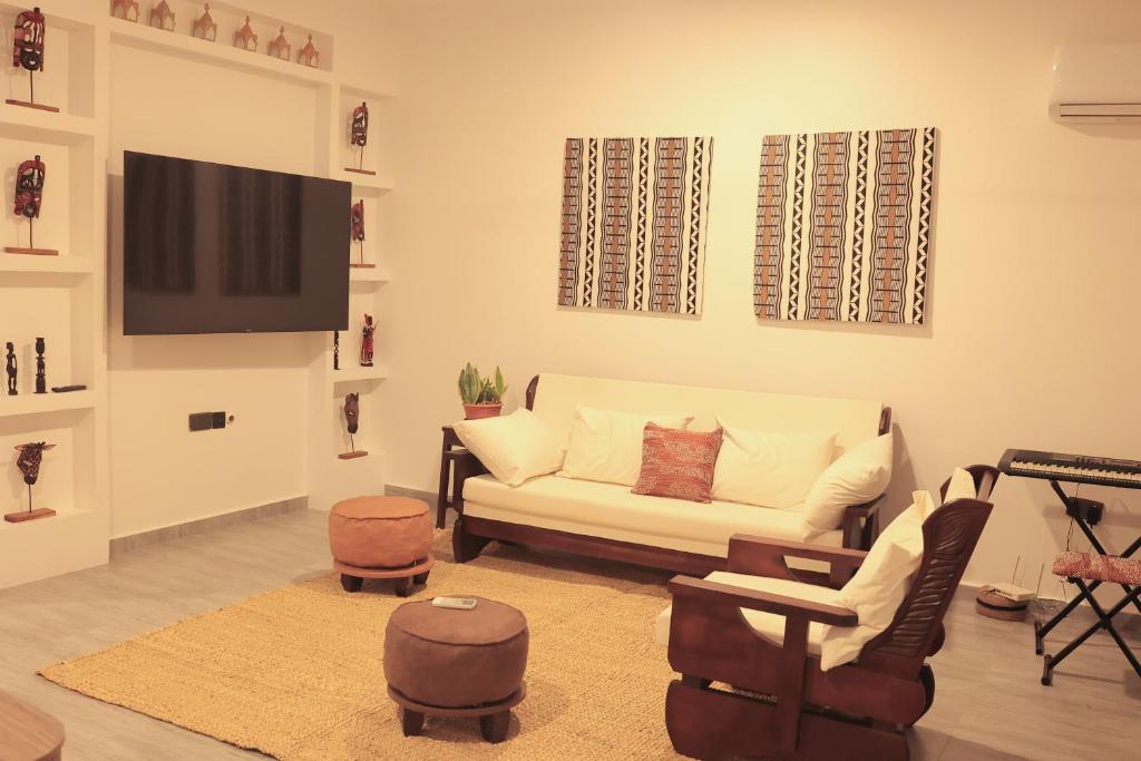a living room with a couch and a flat screen tv at Salasala Suites, Salasala, Mbezi Beach in Dar es Salaam
