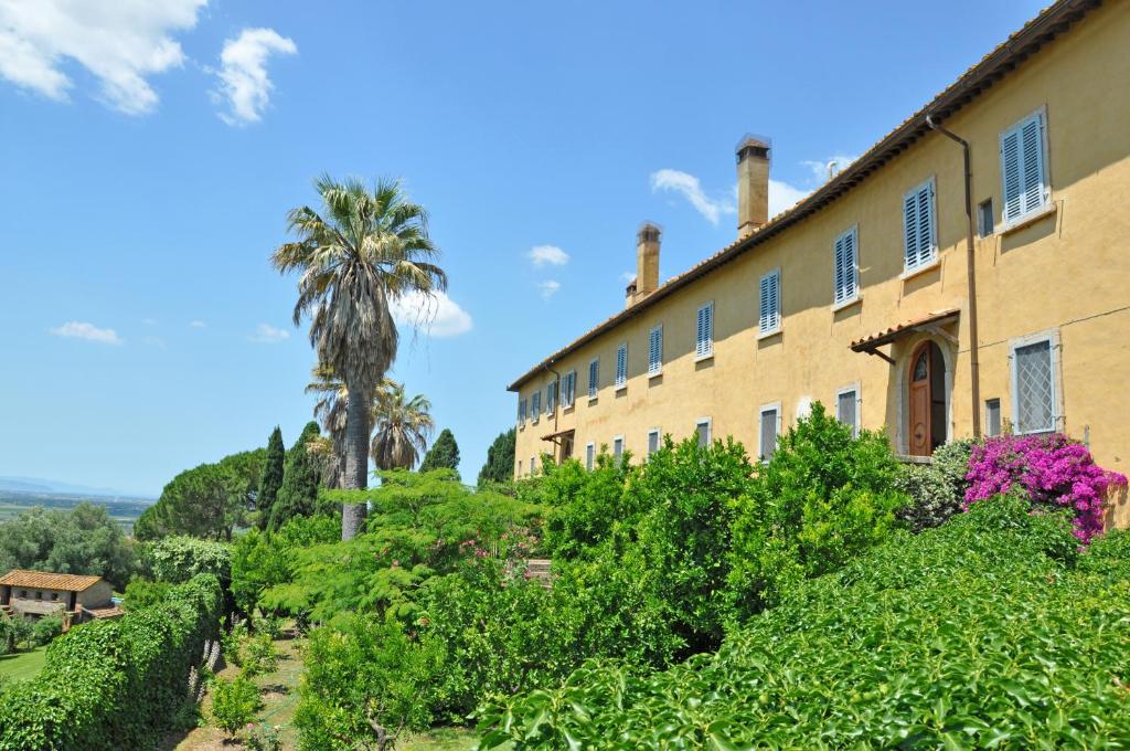 a building with a palm tree and bushes at Il Principe by PosarelliVillas in Marsiliana