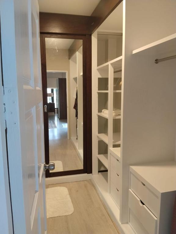 a walk in closet with a mirror and a door at Origin life in Ban Na Sat