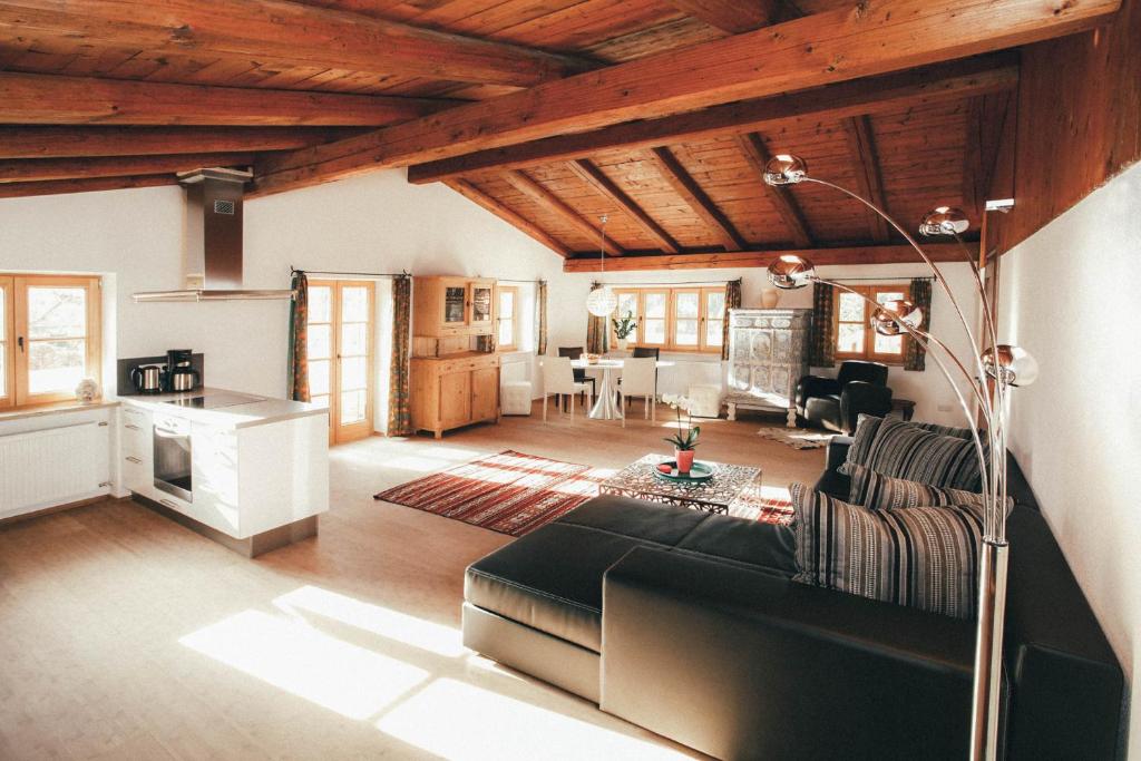 a living room with a black couch and a kitchen at Luna Mia Apartment 4 in Schwangau