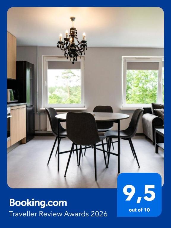 a kitchen and dining room with a table and chairs at Jumara Apartment in Valmiera