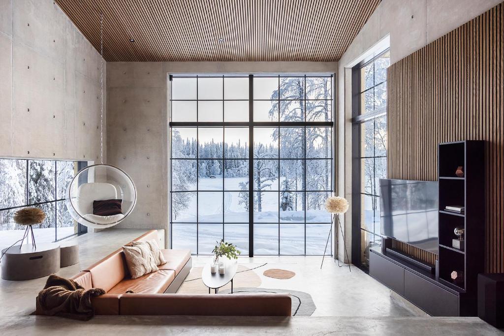 a living room with a couch and a large window at Taikavilla in Kuusamo