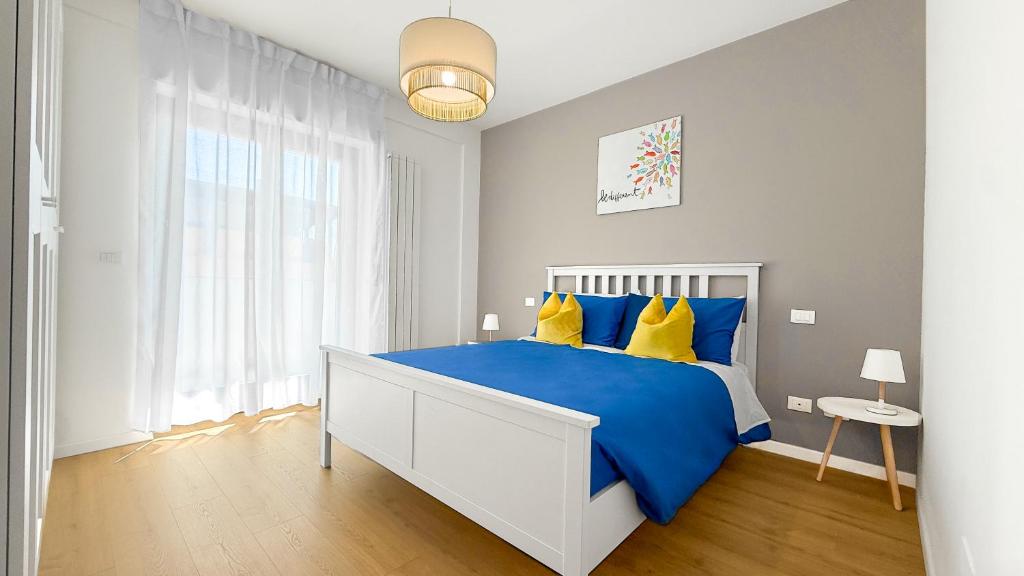 a bedroom with a large bed with blue and yellow pillows at Platinum House in Montesilvano