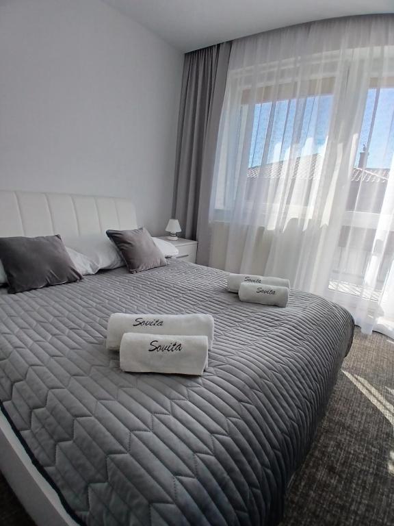a bedroom with a large bed with two towels on it at Villa Sovita in Łeba