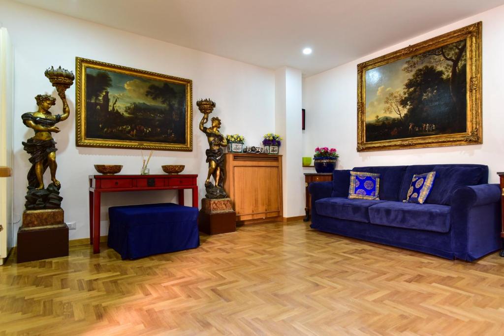 una sala de estar con un sofá azul y una pintura en Elite Rome Apartments, en Roma