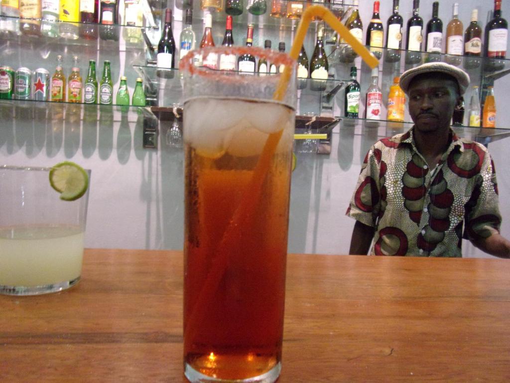 a drink sitting on a table next to a bartender at Melia Hotel in Saly Portudal