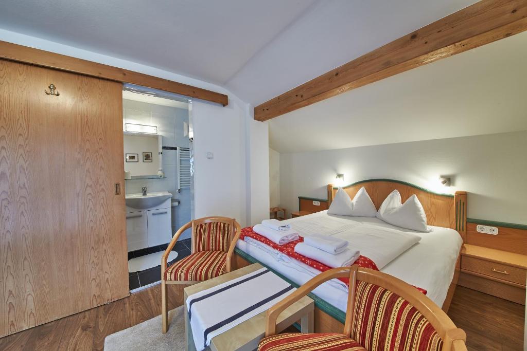 フィーホーフェンにあるHoliday Home Viehhofenのベッド1台と椅子2脚が備わるホテルルームです。