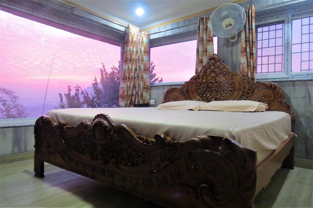 a large bed in a room with a large window at Swami Manjulanand Ashram in Mohan Chatti