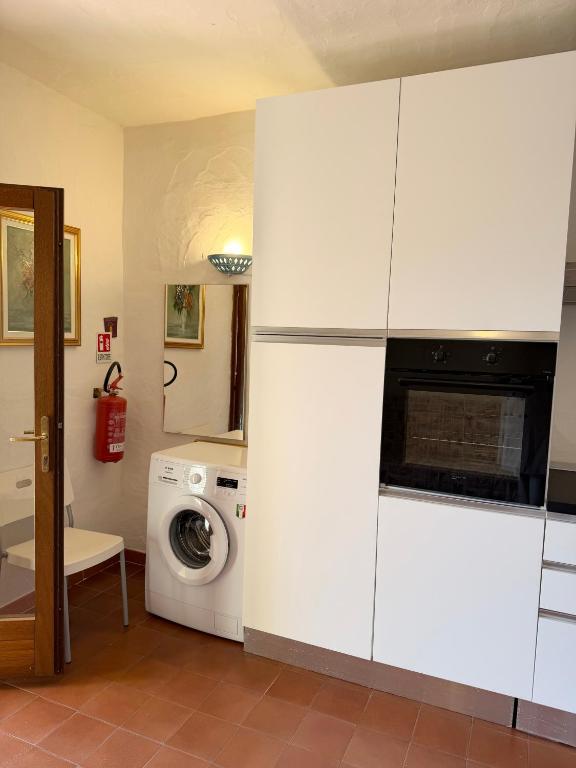 a kitchen with a washer and a washing machine at Bilocali Ibiscus - 700mt dalla spiaggia in Porto Ottiolu