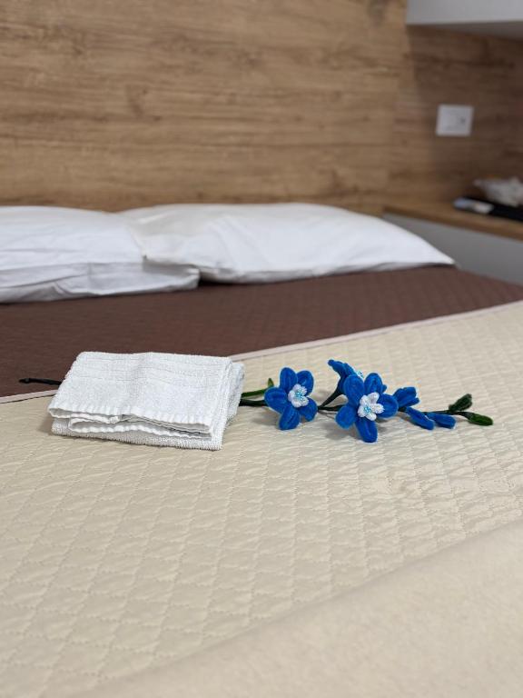 two towels and blue flowers on a bed at Acrita Superior in Mandaradoni