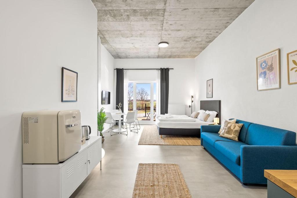 a living room with a blue couch and a living room at SKYRISE Apartments mit Küche, WLAN & Parkplatz - ruhige Lage in Bad Wörishofen