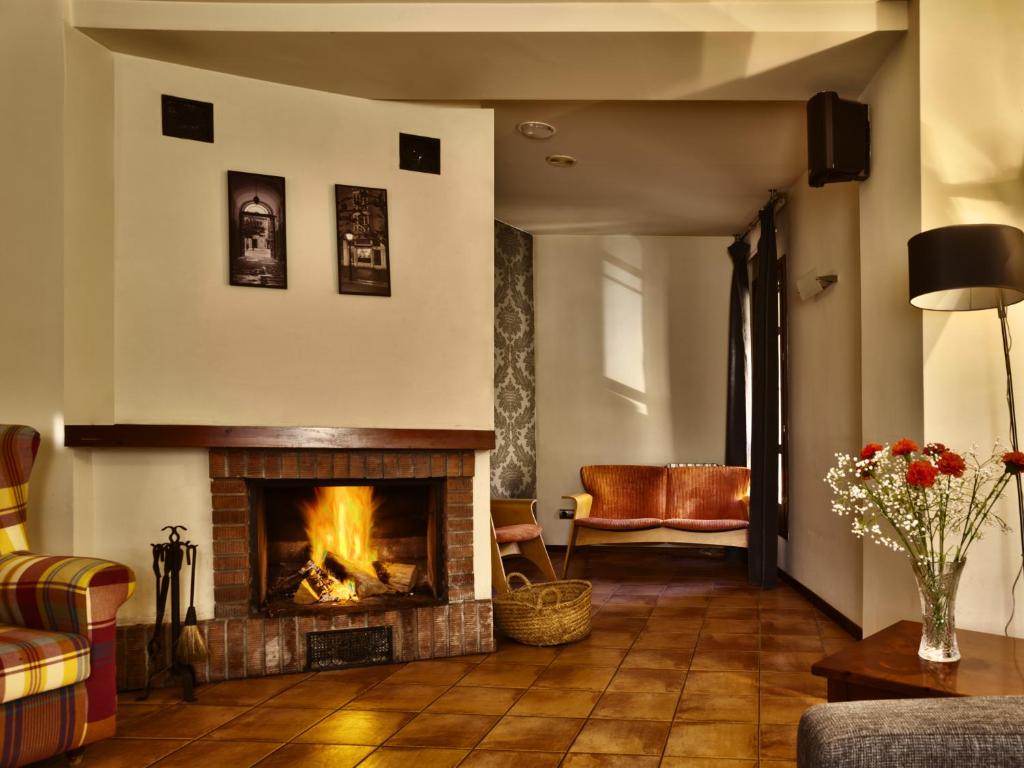 a living room with a fireplace and a couch at Hospederia de Loarre in Loarre