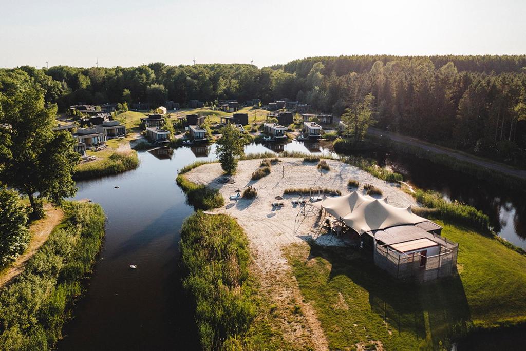 an aerial view of a river with a group of houses at De Parel - Mystical spaces to discover! in Zeewolde