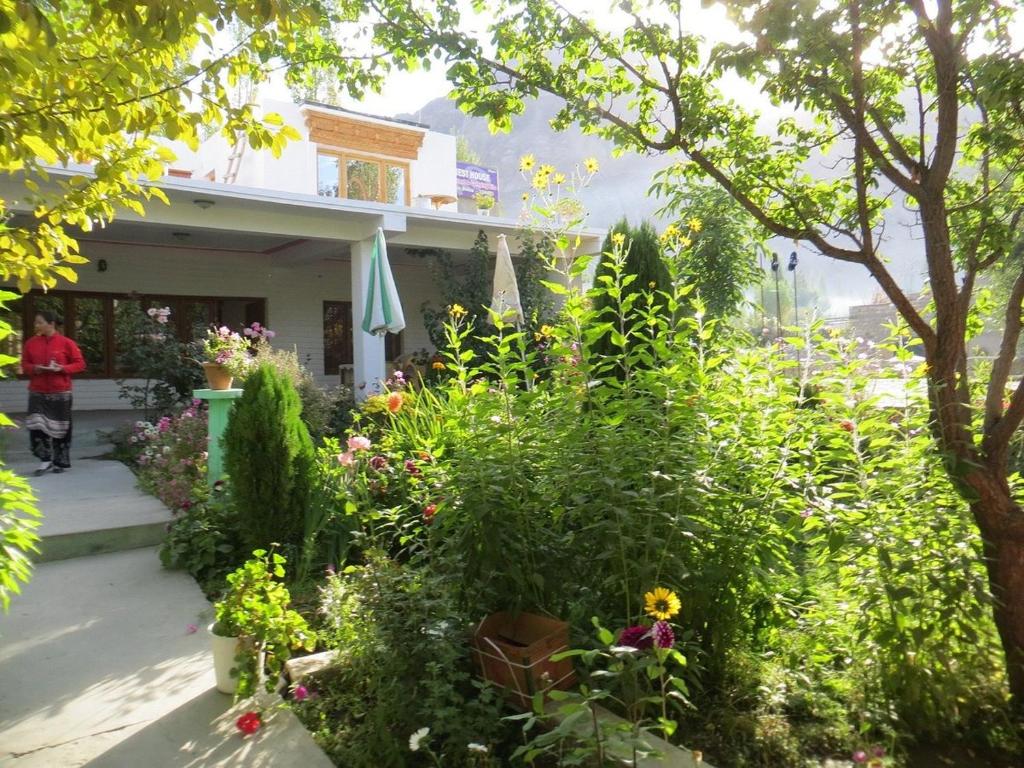a garden with flowers and plants in front of a house at AO Guest House in Nubra