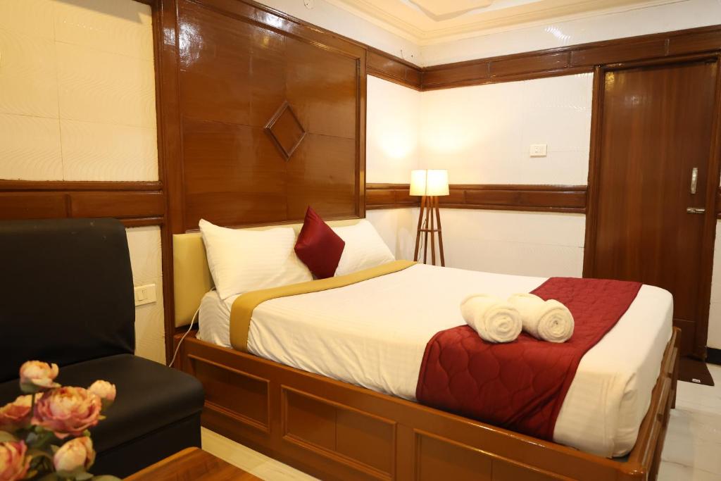 a hotel room with a bed and a chair at SVS Grand in Dindigul