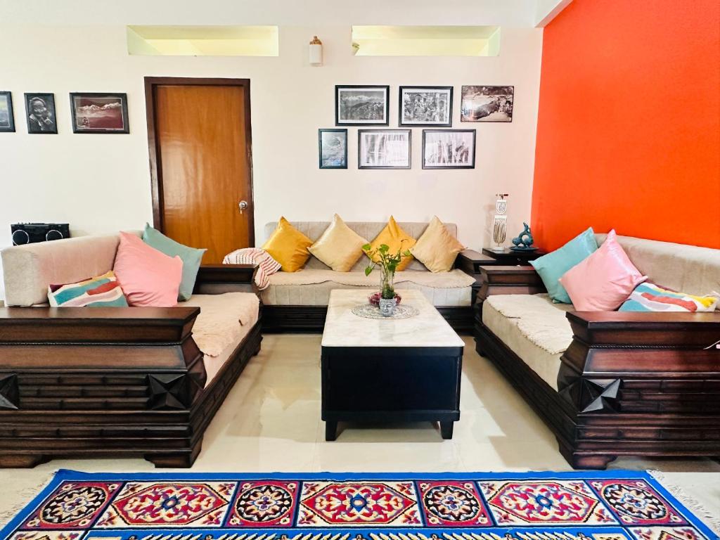 a living room with two couches and a table at J kutir in Siliguri