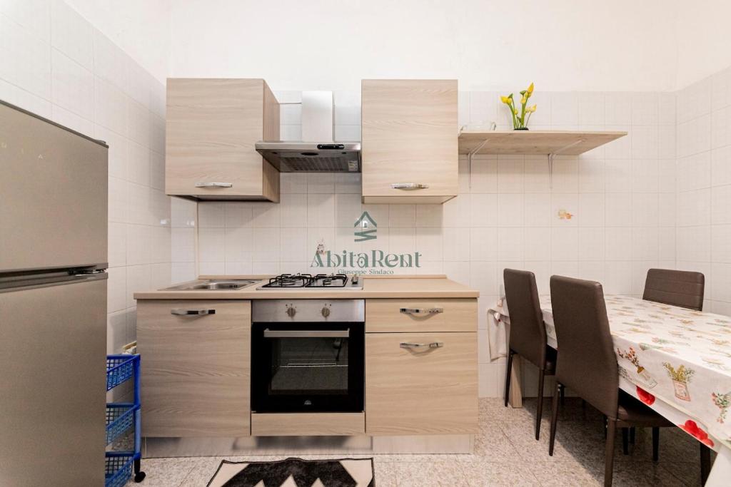 a kitchen with a stove and a table with chairs at La Dimora del Centro - San Foca in San Foca