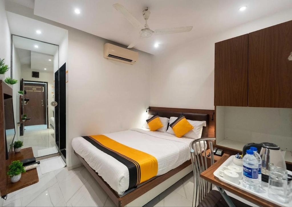 a bedroom with a bed and a table and a desk at Glitz Rexton Inn - Near IIT Powai in Mumbai